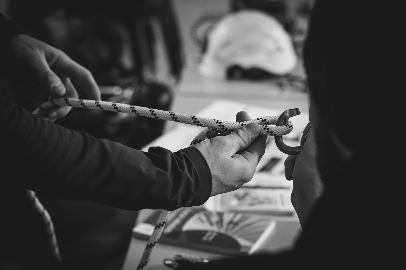 Hands tying a knot in a rope during a rope access briefing