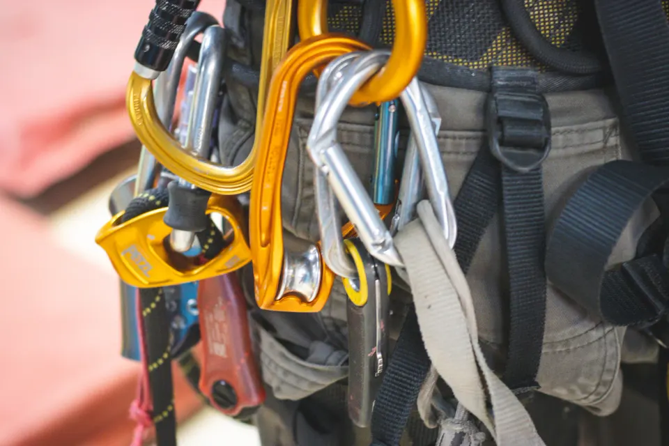 Close-up of carabiners and rope access equipment attached to a harness